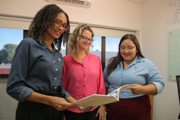 Tr&ecirc;s colaboradoras da Ceva lendo um folheto informativo